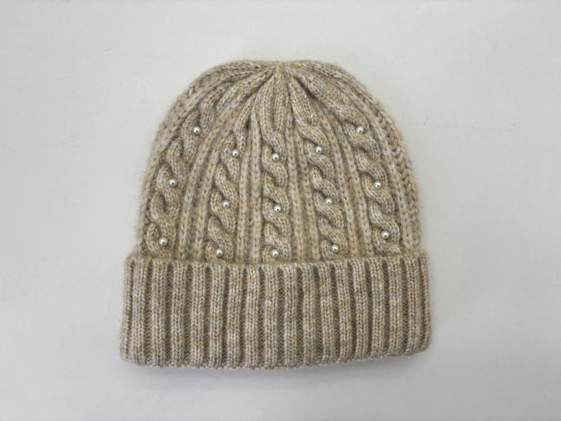 Beige cable knit winter beanie hat with pearl bead embellishments and ribbed cuff, flat lay on white background