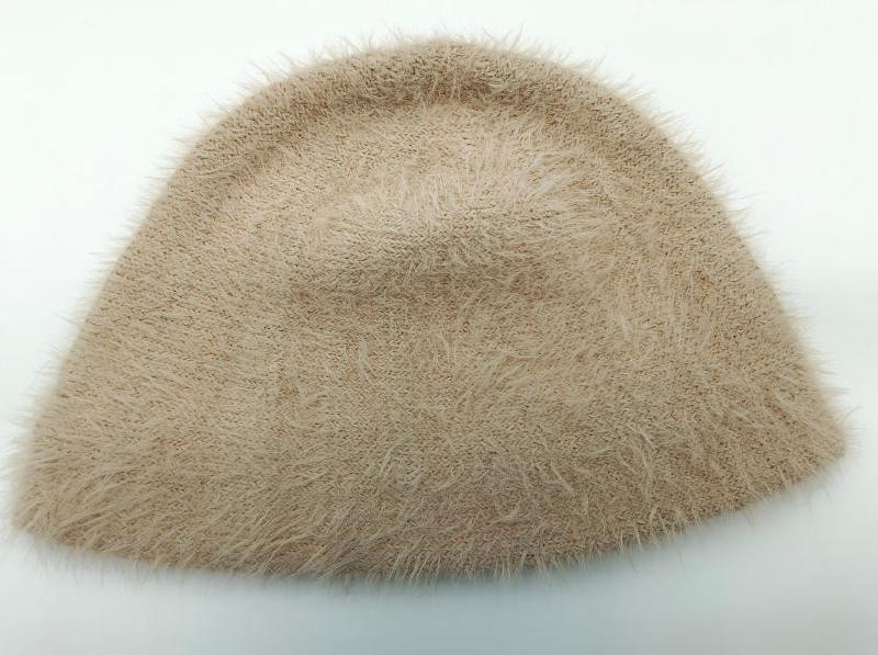 Beige fluffy eyelash knit bucket hat with soft furry texture, laid flat on white background