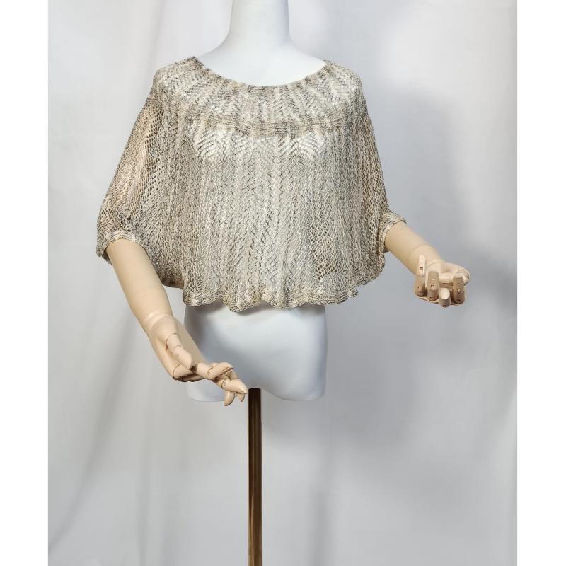 Beige and gold metallic open-knit crochet cropped poncho top displayed on a white mannequin with wooden articulated hands