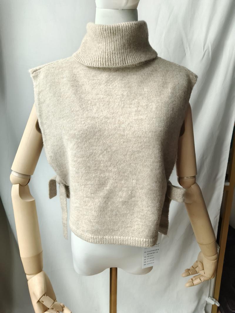 Beige knit sleeveless turtleneck sweater vest with side tie details displayed on a mannequin, soft wool blend