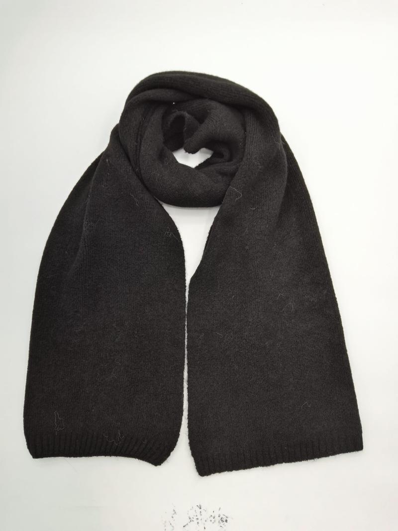 Black chunky knit winter scarf folded in loop shape with ribbed edges, laid flat on white background