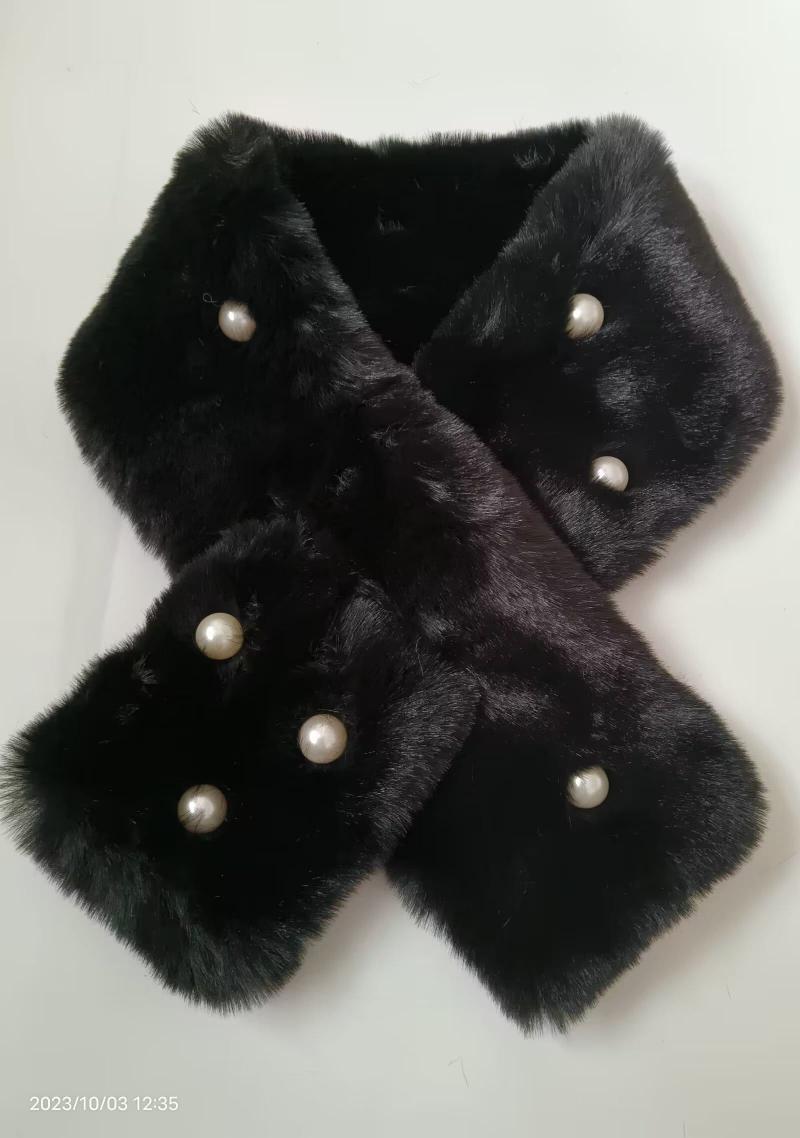 Black faux fur crossover neck scarf with decorative white pearl buttons laid flat on white background