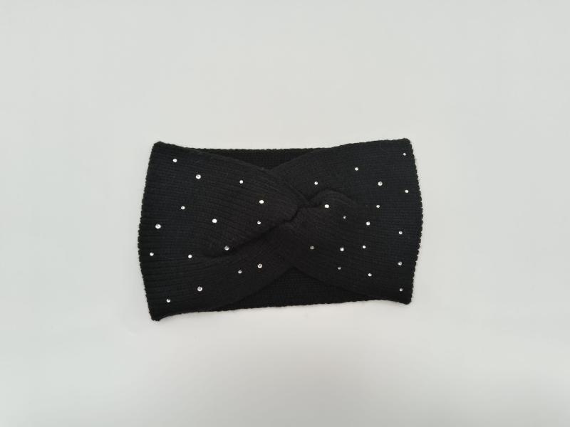Black ribbed knit twist headband with scattered silver crystal rhinestone studs laid flat on white background