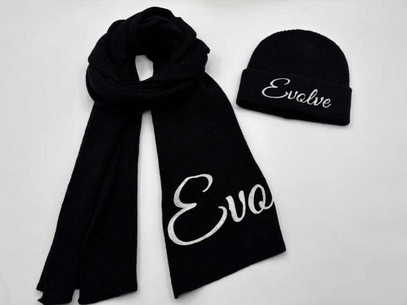 Black ribbed knit winter scarf and beanie hat set with white embroidered cursive text on white background