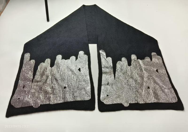 Black ribbed knit scarf laid flat showing silver metallic city skyline embroidered pattern on both ends