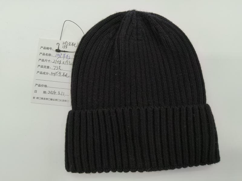 Black ribbed knit wool beanie hat with folded cuff displayed flat on white background with product tag