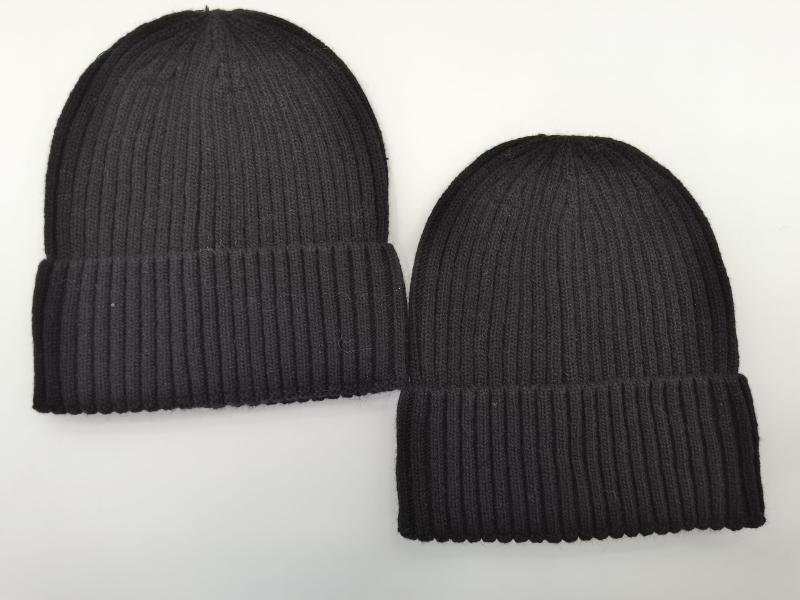 Two black ribbed knit cuffed beanie hats laid flat on white background, one larger and one smaller