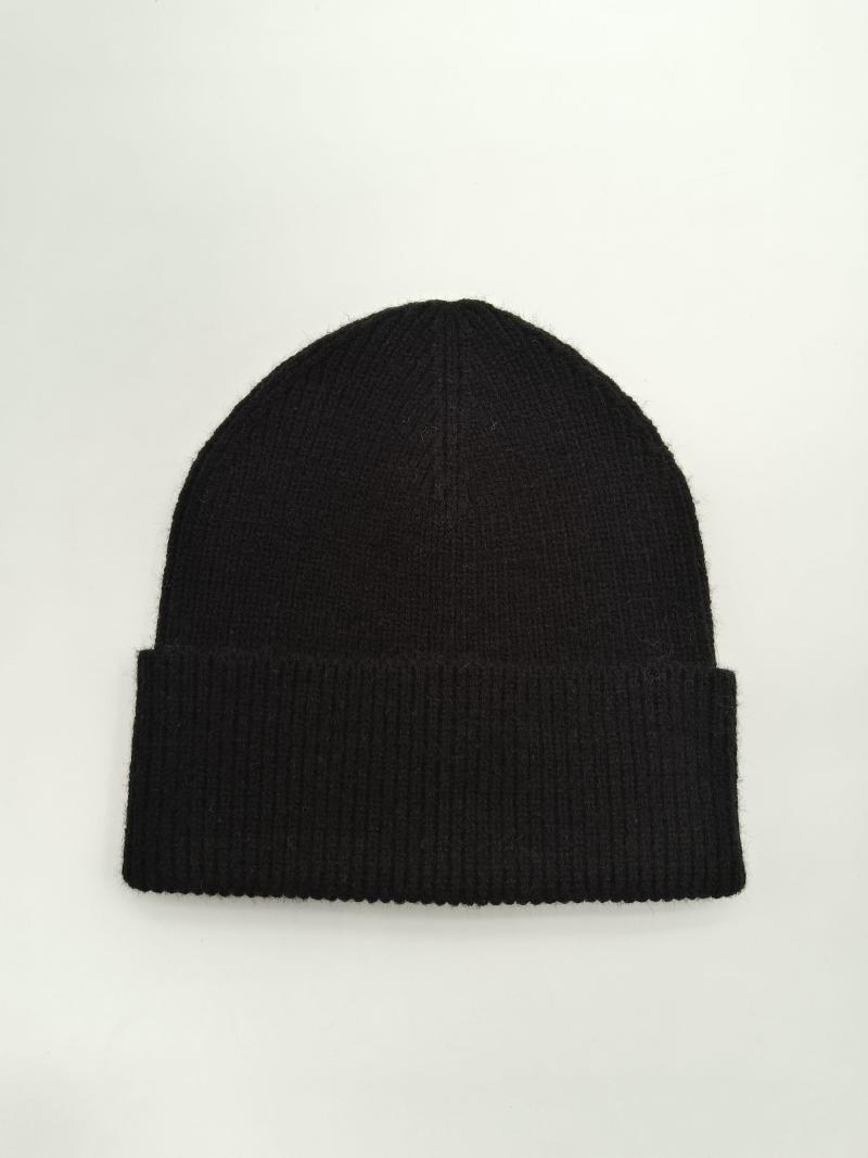 Black ribbed knit beanie with folded cuff laid flat on white background, soft wool winter hat
