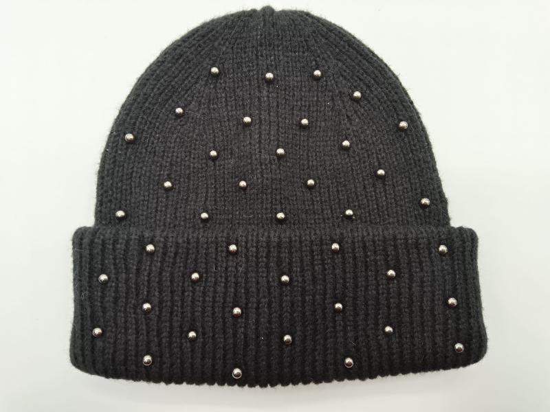 Black ribbed knit winter beanie hat with scattered silver dome studs and folded cuff, displayed flat on white background