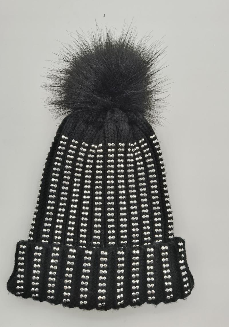 Black ribbed knit winter beanie covered in silver crystal studs with a large black faux fur pom pom on top