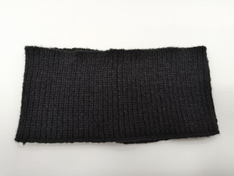 Close-up of a black ribbed knit fabric swatch with vertical rib texture, shown flat on white background