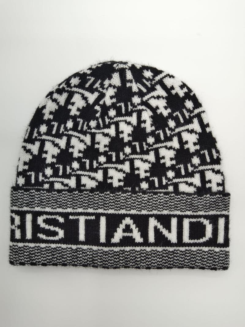 Black and white houndstooth patterned knit beanie with ribbed logo cuff band, laid flat on white background