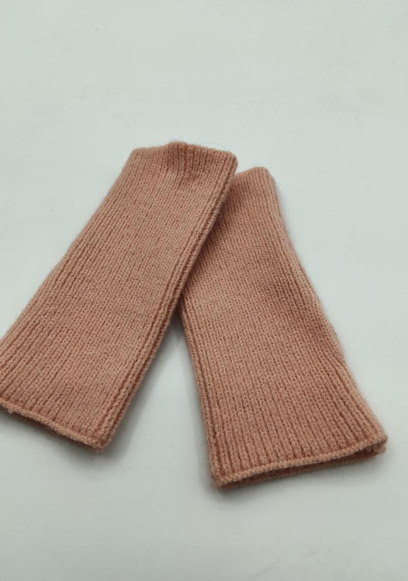 Pair of blush pink ribbed knit fingerless gloves wrist warmers laid flat on white background