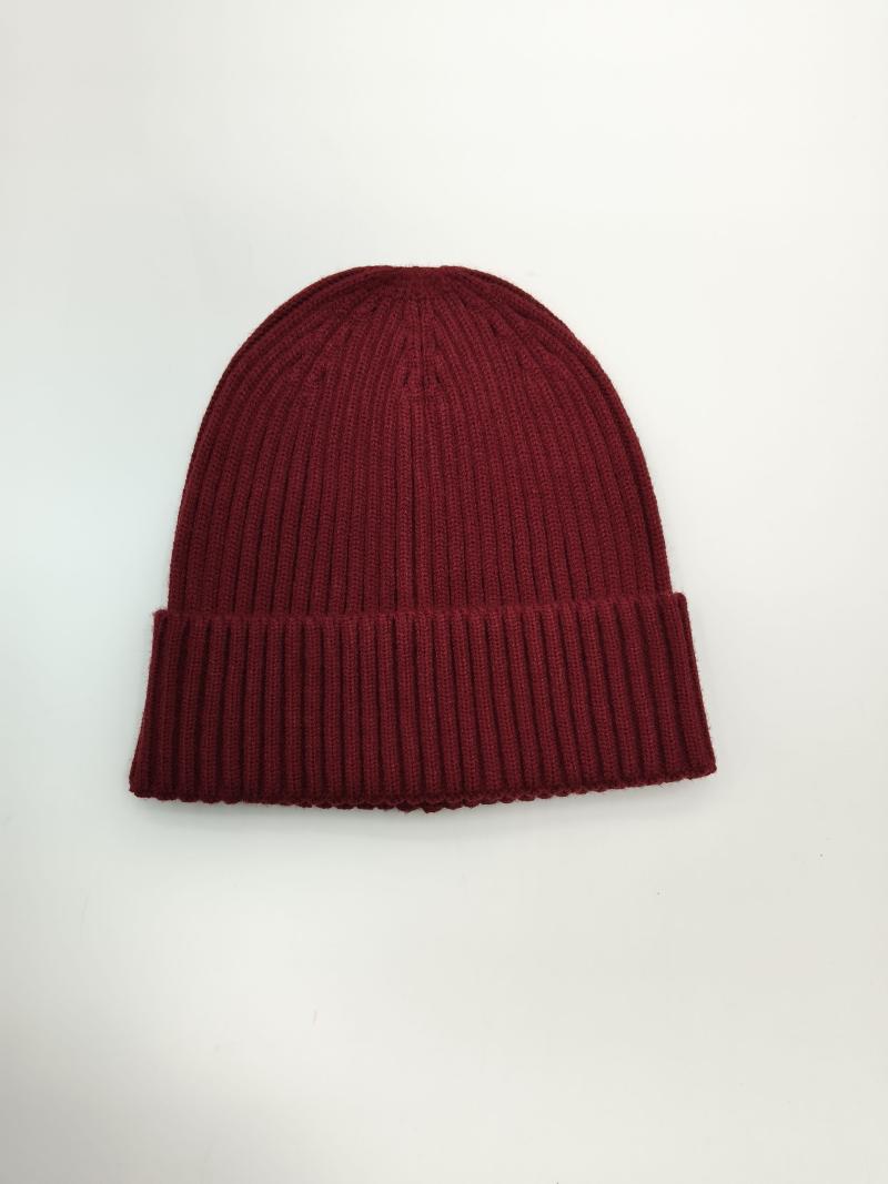 Burgundy ribbed knit beanie hat with double folded cuff laid flat on white background