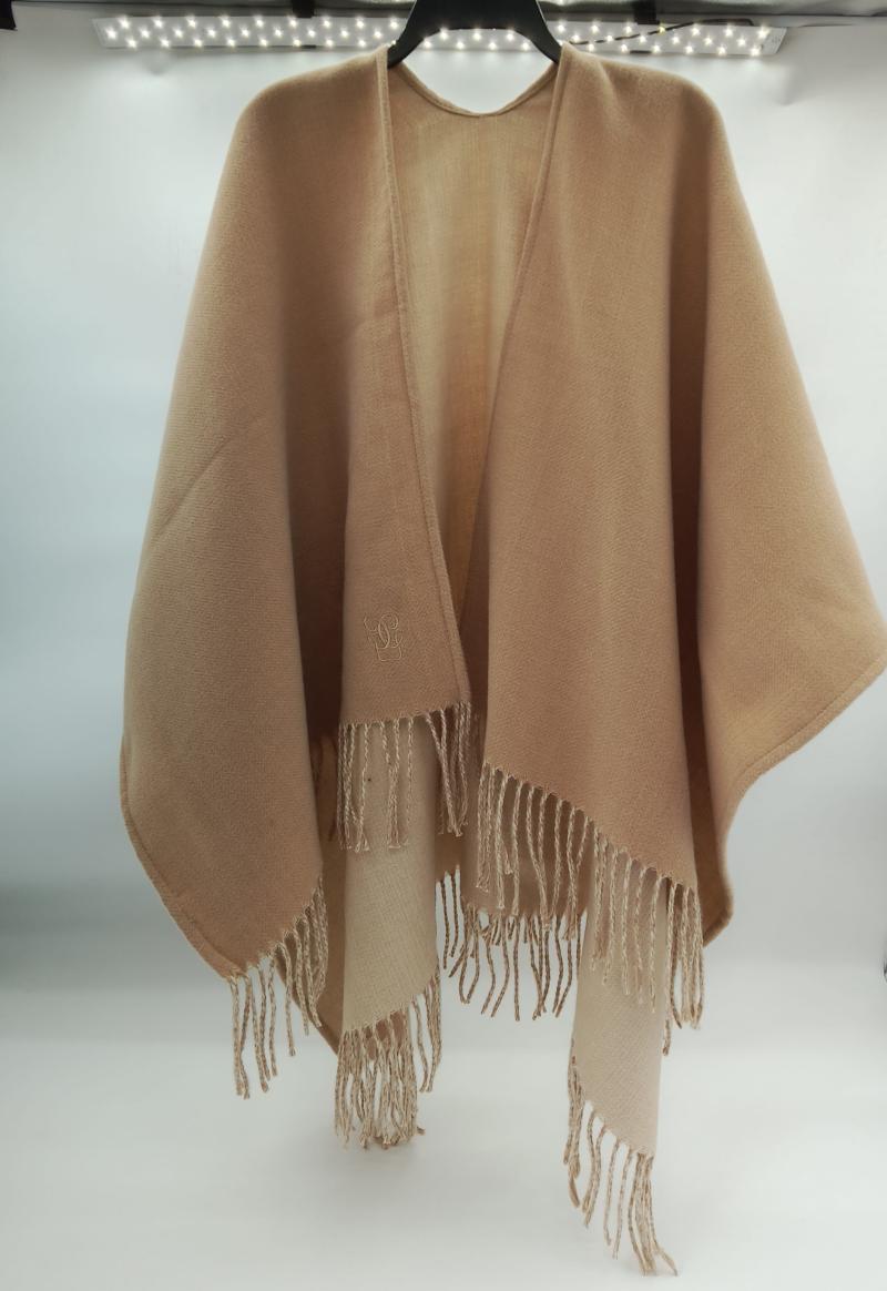 Camel beige fringed wrap poncho cape in soft wool blend, open front design with tassel hem, displayed on hanger