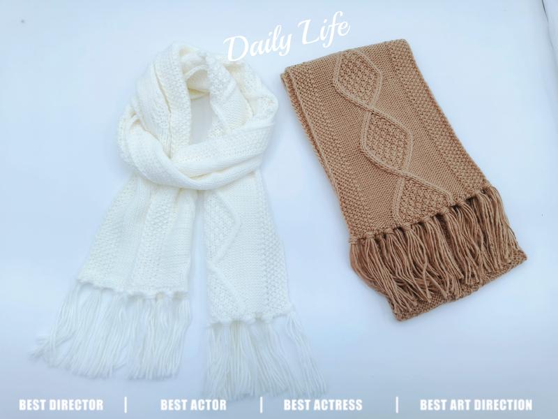 Two knit scarves with fringe ends: white cable-knit scarf and folded camel scarf with raised leaf pattern on white background