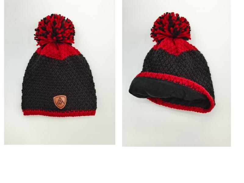 Black and red chunky knit pom-pom beanie with leather logo patch and fleece lining shown front and interior views