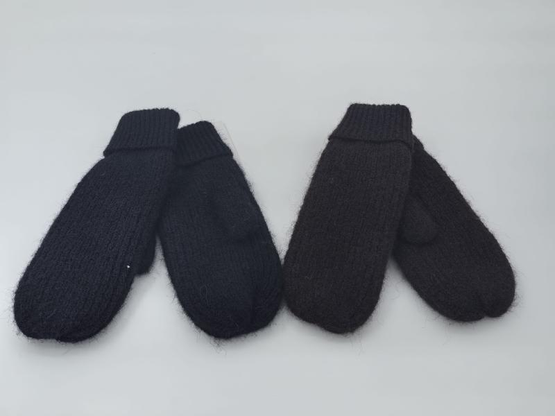 Two pairs of chunky knit mittens in black and dark brown laid flat on white background, showing ribbed cuffs and fluffy texture