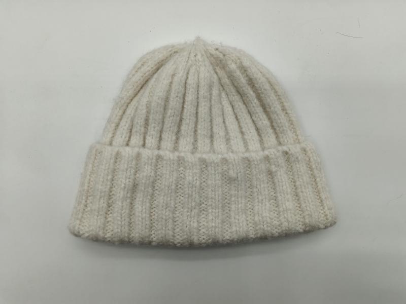 Cream off-white chunky ribbed knit beanie hat with folded cuff, laid flat on white background