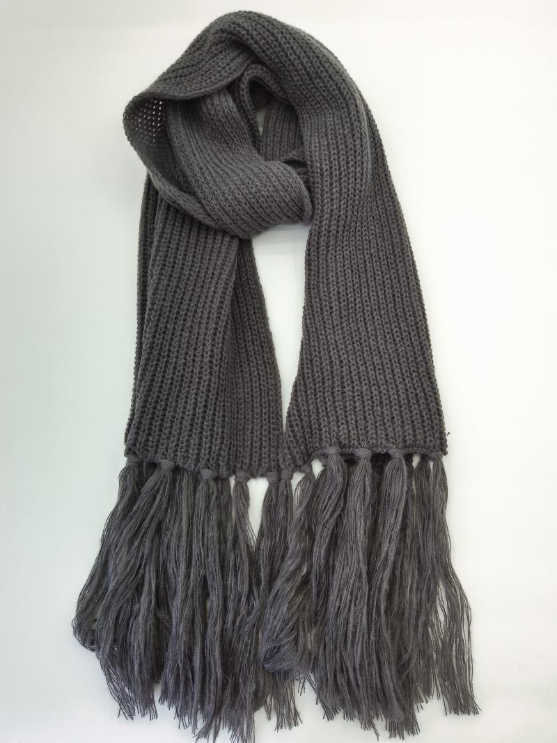 Charcoal gray chunky ribbed knit scarf with long tassel fringe ends, loosely draped on white background