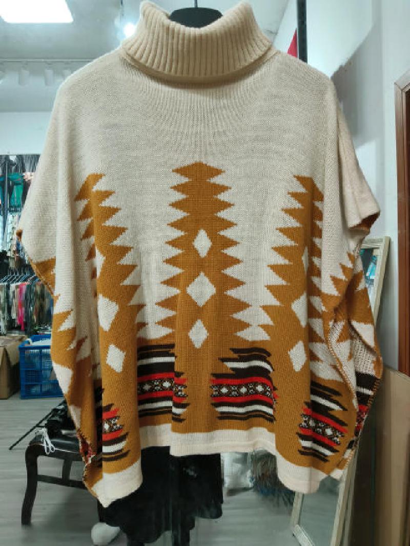 Oversized cream knit poncho sweater with mustard and red Aztec geometric pattern and turtleneck collar on hanger