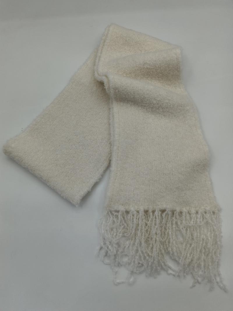 Soft cream boucle knit scarf folded on white background, showing textured fabric and knotted fringe ends