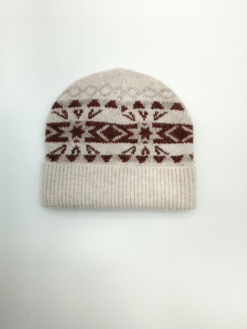 Cream knitted beanie hat with rust brown Fair Isle Nordic geometric snowflake pattern and ribbed cuff, flat lay on white background