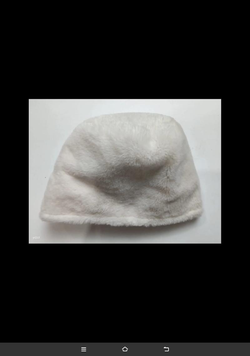 Cream white faux fur plush bucket hat laid flat on white surface, soft fluffy texture winter accessory