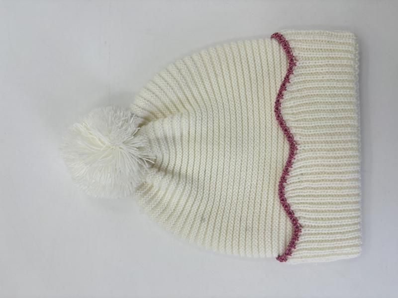 Cream chunky ribbed knit winter beanie hat with fluffy pom-pom top and decorative pink zigzag stitch trim at brim