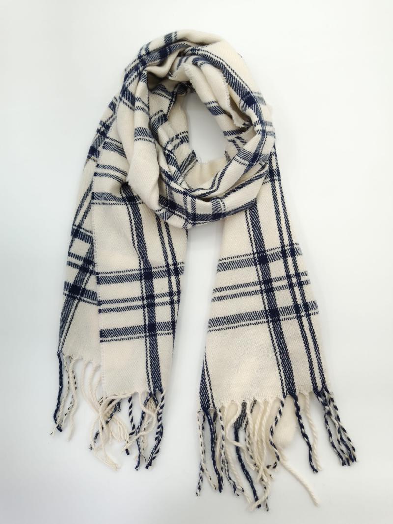 Cream and navy blue plaid woven scarf with twisted fringe ends, looped and laid flat on white background