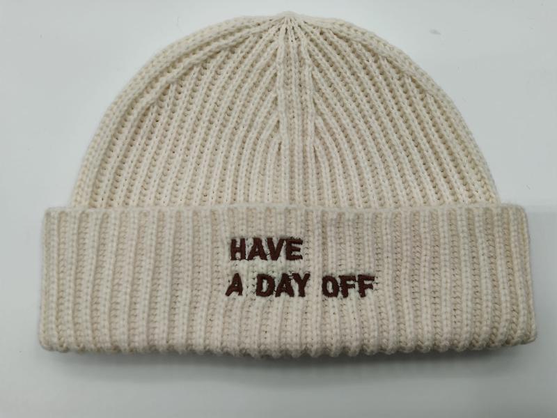 Cream chunky ribbed knit beanie hat with brown embroidered text 'Have A Day Off' on folded cuff