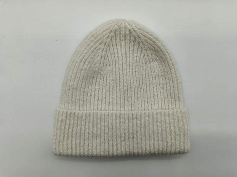 Cream off-white ribbed knit winter beanie hat with folded cuff displayed flat on light grey background
