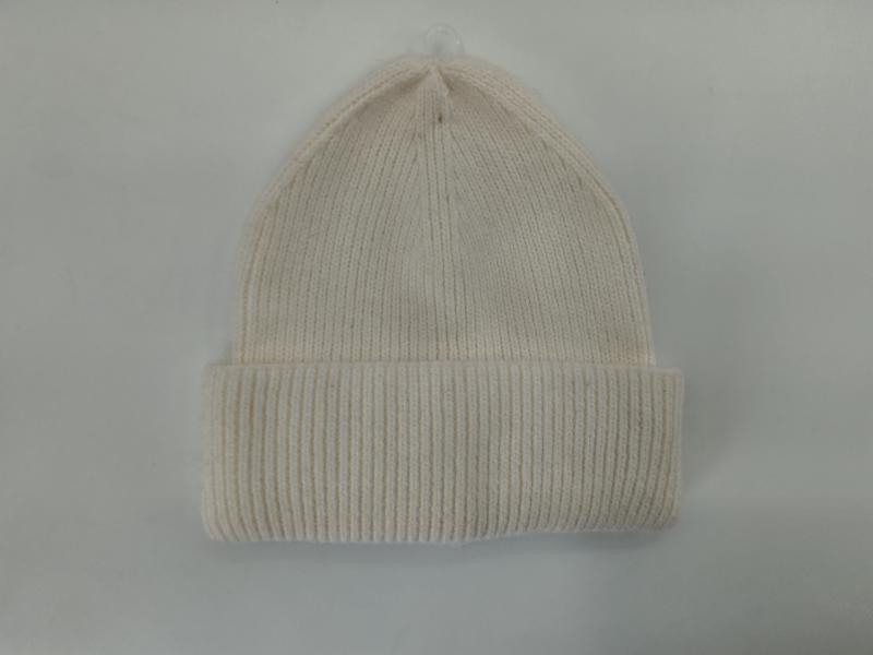 Cream off-white ribbed knit beanie hat with folded cuff displayed flat on light gray background
