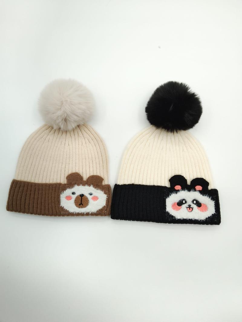 Two ribbed knit beanies with pom-poms featuring bear and panda cartoon faces on brown and black contrast cuffs