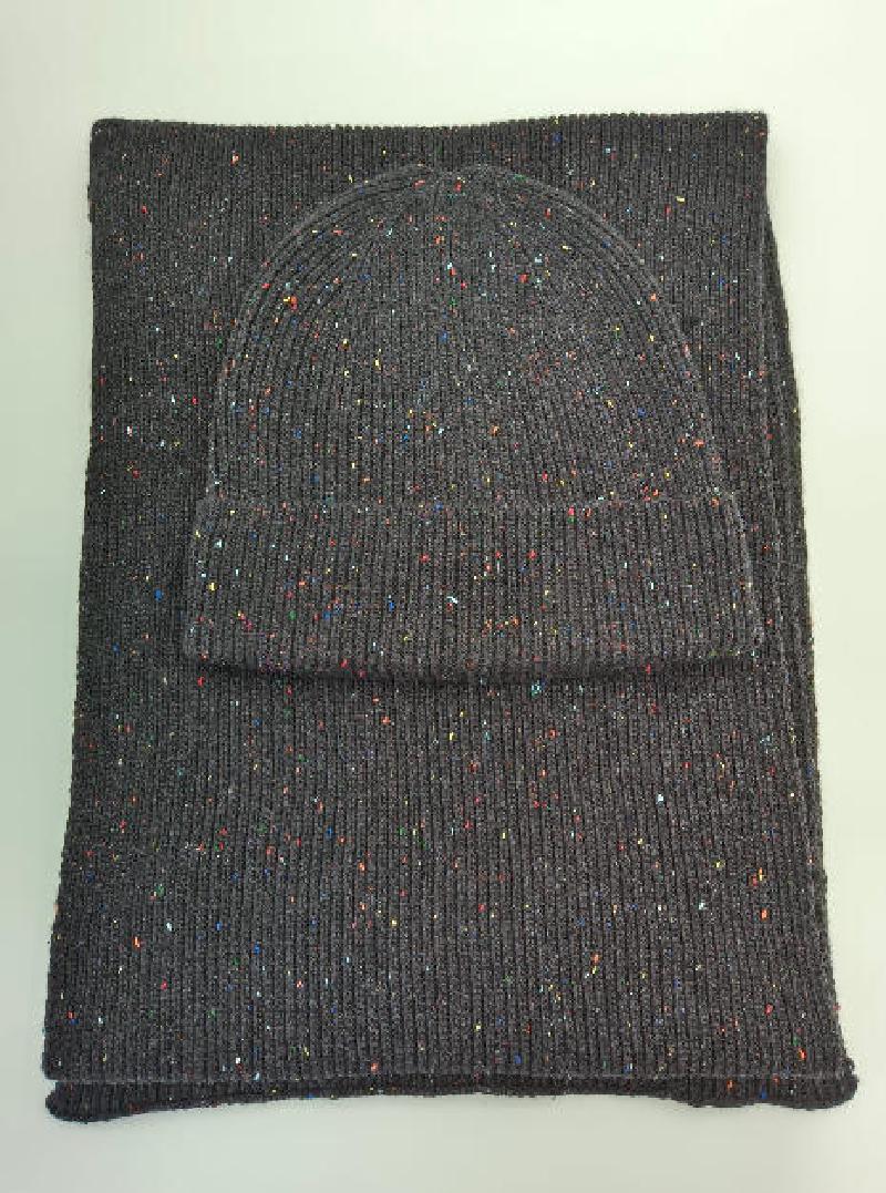 Dark grey knitted beanie hat and matching scarf set with multicolor confetti speckle pattern, laid flat on white background