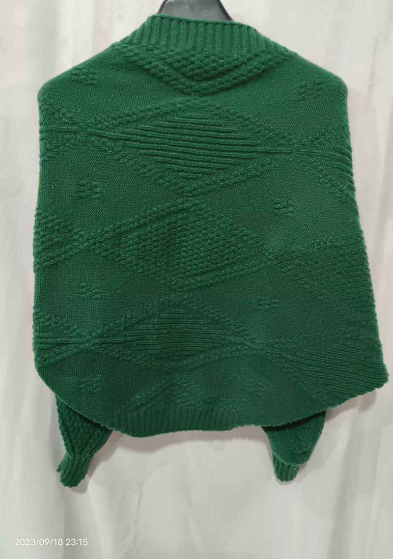 Back view of emerald green chunky knit poncho sweater with diamond geometric texture pattern displayed on hanger