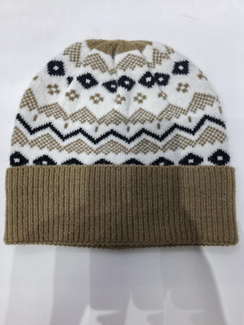 Folded Fair Isle knit winter beanie hat with tan ribbed cuff, white body, navy and tan chevron zigzag and floral pattern