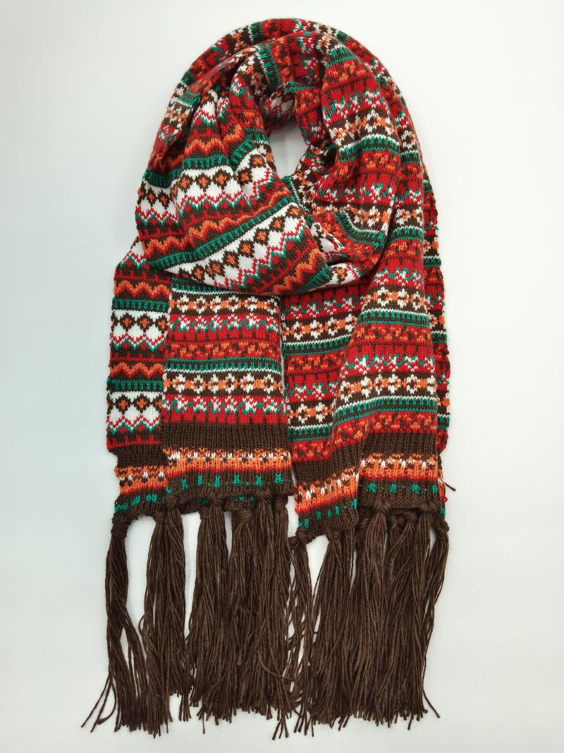Coiled fair isle knit scarf in red, green, orange and white geometric pattern with long brown tassel fringe ends