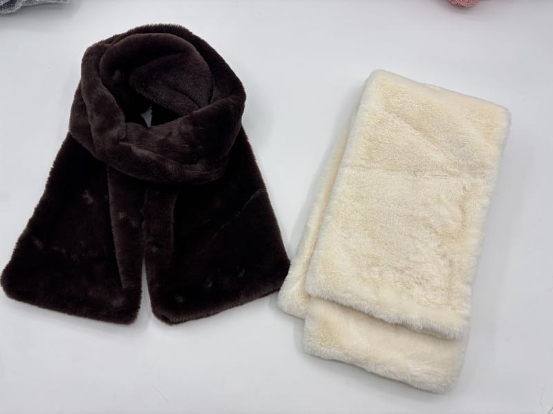 Two faux fur plush scarves side by side, one dark chocolate brown draped and one cream white folded, soft fluffy texture
