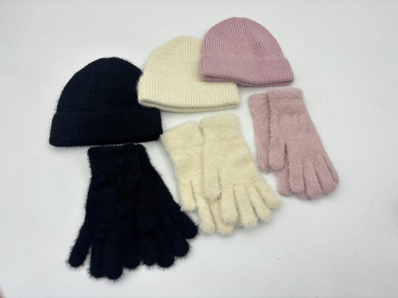 Three matching sets of fuzzy knit gloves and ribbed beanies in black, cream, and dusty pink arranged on white background