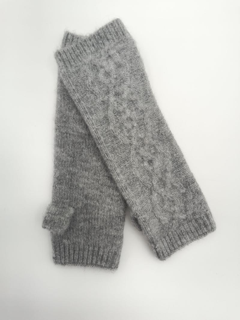 Pair of gray cable knit fingerless gloves with ribbed cuffs and thumb holes laid flat on white background