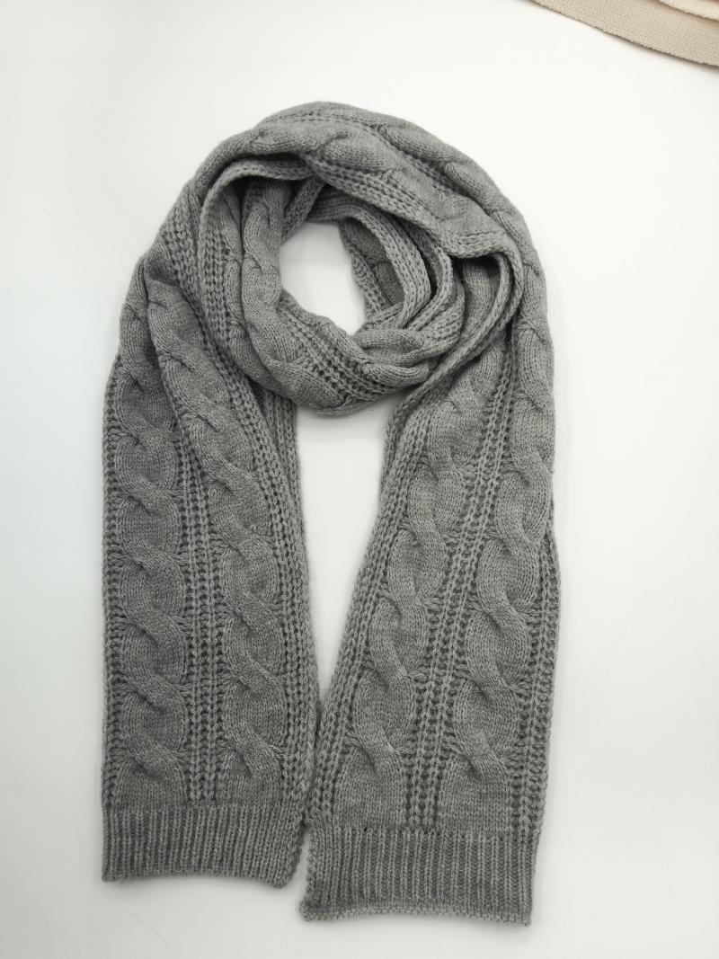 Gray cable knit scarf looped and laid flat on white surface showing braided texture and ribbed cuffs