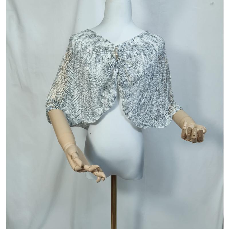 White mannequin wearing a sheer gray snakeskin print mesh capelet with a decorative brooch closure at the front neckline