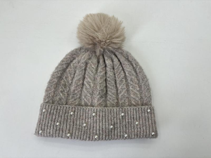 Grey cable knit winter beanie hat with faux fur pom pom on top and pearl bead embellishments along ribbed cuff