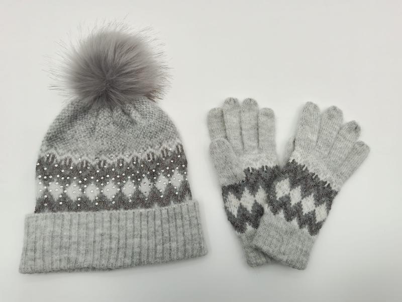 Grey knitted Fair Isle beanie hat with fur pom-pom and pearl embellishments alongside matching knit gloves set