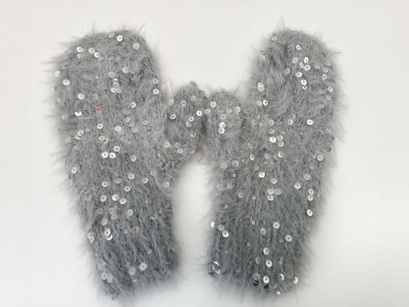 Pair of grey fluffy eyelash yarn mittens with silver sequin embellishments laid flat on white background