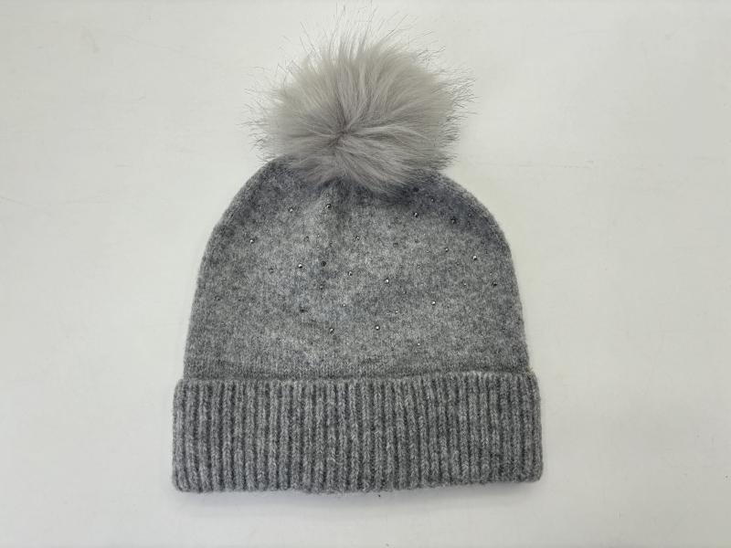 Grey knitted winter beanie hat with fluffy faux fur pom pom on top and scattered rhinestone embellishments on ribbed cuff
