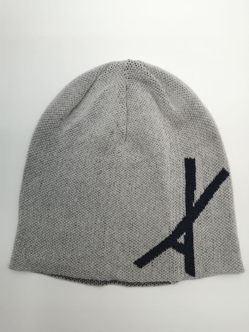 Light grey fine knit slouch beanie hat with large navy blue letter graphic on front, laid flat on white background