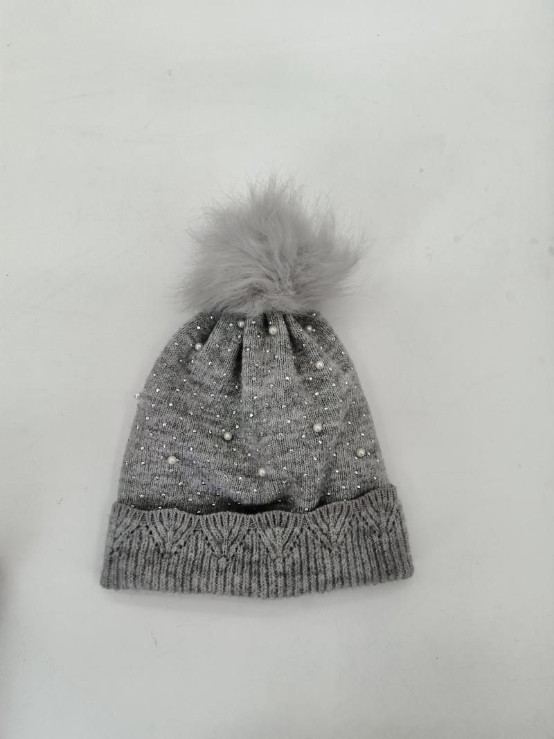 Grey knitted winter beanie hat with scattered pearl and rhinestone details, cable knit cuff, and fluffy faux fur pompom on top