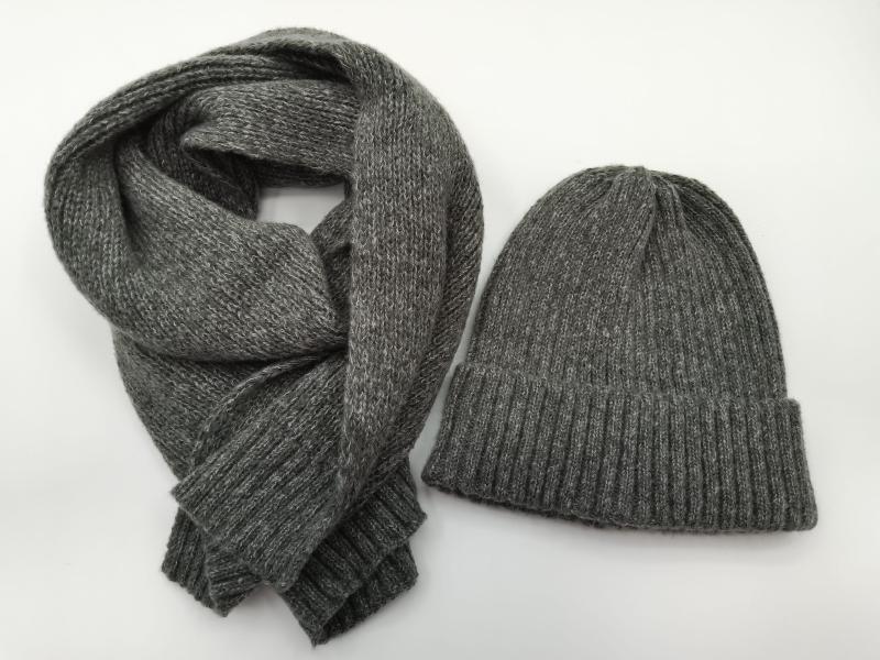 Heather grey ribbed knit beanie hat and matching long knit scarf set laid flat on white background